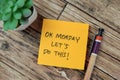 Concept of OK Monday Let's Do This! write on sticky notes isolated on Wooden Table