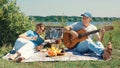 The concept of old age, leisure. A happy elderly couple, a man and a woman, relaxing with a book and a guitar Royalty Free Stock Photo