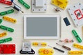 Concept of online courses in robotics, electronics. Tablet is surrounded by various electronic parts on white wooden