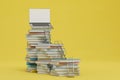 the concept of online learning. stacks of books on which stairs lead to an open laptop on a yellow background. 3D render