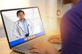 Concept of online medical healthcare, shows laptop display with Asian male doctor smiling, telehealth, telemedicine video call