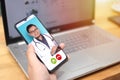 Concept of online medical healthcare, shows smartphone app with Asian male doctor smiling, telehealth, telemedicine video call