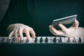 The concept of online piano learning. One hand plays on the keyboard  the other holds the tablet. Close-up  selective focus  copy Royalty Free Stock Photo