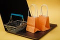 Concept of online shopping. Orange bags and shopping cart on keyboard