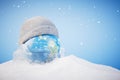 The concept of the onset of cold weather. A planet in a hat and in the snow. 3D render