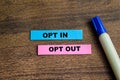 Concept of Opt in and Opt Out write on sticky notes isolated on Wooden Table