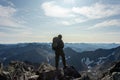 The concept of outdoor activities in the mountains. Man traveler on a background of mountains. Atmospheric view of the snowy slope