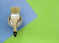 Concept of painting works. Paintbrush on a can of paint, green-blue bright background, top view Royalty Free Stock Photo