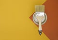 Concept of painting works. Paintbrush on a can of paint, yellow-red bright background, top view Royalty Free Stock Photo