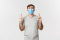 Concept of pandemic, covid-19 and social-distancing. Hopeful worried guy in medical mask, cross fingers for good luck