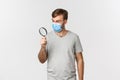 Concept of pandemic, covid-19 and social-distancing. Image of surprised man in medical mask, searching for something and