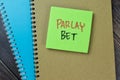 Concept of Parlay Bet write on sticky notes isolated on Wooden Table