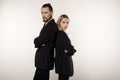 Concept of partnership in business. Handsome man and beautiful woman, both in black suits standing back to back with Royalty Free Stock Photo