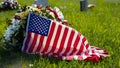 American flag draped over grave with flowers honoring national holidays and veteran. Concept Royalty Free Stock Photo