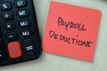 Concept of Payroll Deductions write on sticky notes isolated on Wooden Table