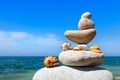 Concept of peace and harmony. A pyramid of white stones and shells on background of summer sea Royalty Free Stock Photo