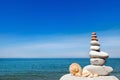 Concept of peace and harmony. A pyramid of white stones and shells on background of summer sea Royalty Free Stock Photo