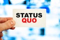 Concept of a person holding a business card with the words - Status quo