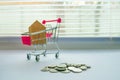 The concept of personal spending, shopping and finance. House, Trolley, Ladder Up on White Background, Money, Finance, Tax, Profit