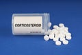 On a blue surface are pills and a dusty jar with the inscription - Corticosteroid Royalty Free Stock Photo