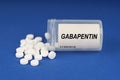 On a blue surface are pills and a dusty jar with the inscription - Gabapentin