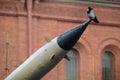 Concept photo of a crow sitting on the end of a military missile. A symbol of anxiety, war, peace. Anxious feelings about the fate