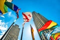 Concept photo of global international corporate business. Skyscrapers and international flags against blue sky at sunny day Royalty Free Stock Photo