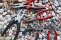 Concept Photo With Set Of Different Types Of Mechanics Pliers On Smooth Rocks