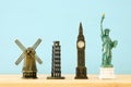 concept photo of some of the world famous landmark for travel , small statues over wooden table.