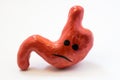 Concept photo of unhappy, sad stomach with discomfort, illness or disorder. Figure of stomach with sad smile, which symbolizes gas