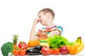 Concept photo of an unloved food - portrait of a boy with an aversion to vegetables and fruits on a white Royalty Free Stock Photo