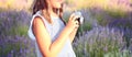 The concept of photography. Girl in a striped dress holds a camera in her hands and shoots a summer landscape against a background