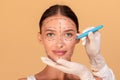 Concept of plastic surgery. Lady changing her appearance at cosmetology clinic, plastic surgeon making marks on her face Royalty Free Stock Photo