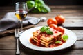 A Plate Of Lasagna On A Wooden Table With Basil And Tomatoes In The Background And A Glass Of Wine In The Foregro. Generative AI