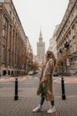 Concept of Poland lifestyle and travel towns in Warsaw. Young beautiful woman walking with bouguet of tulips on Warsaw