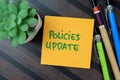 Concept of Policies Update write on sticky notes isolated on Wooden Table
