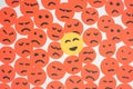 Concept for a positive attitude made with round shaped papers looking like sad faces with one that has smile and stands out