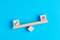 Concept of positive evaluation in decision making, approval or voting. Tick mark outweighs cross mark on and imbalanced seesaw