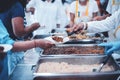 The concept of poverty and food shortages: homeless people wait to receive food donations from donors