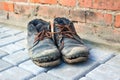 The concept of poverty, homelessness, lack of money. Dirty old shoes on paveng floor. A pair of dirty boots. Old worn Royalty Free Stock Photo