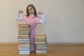 Concept The power of knowledge. A girl with a pile of books shows her strength. Education concept. copy space Royalty Free Stock Photo