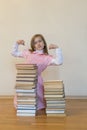 Concept The power of knowledge. A girl with a pile of books shows her strength. Education concept. copy space. vertical photo Royalty Free Stock Photo