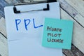 Concept of PPL - Private Pilot License write on sticky notes isolated on Wooden Table Royalty Free Stock Photo