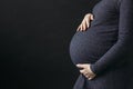 A pregnant woman in a dress holds her stomach with her hands Royalty Free Stock Photo