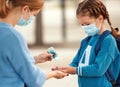 Concept of preventing a coronavirus covid-19 and viral infections. Mother treats her child`s hands with a sanitizer before school