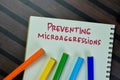 Concept of Preventing Microaggressions write on book isolated on Wooden Table