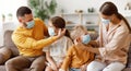 Concept of prevention of coronavirus infection. happy family: caring parents put protective medical masks on their children in