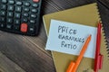 Concept of Price Earnings Ratio write on sticky notes isolated on Wooden Table Royalty Free Stock Photo