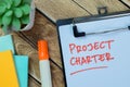 Concept of Project Charter write on sticky notes isolated on Wooden Table