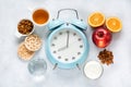 Concept of proper portioned nutrition for health calculated by the clock. Group useful breakfast coffee, tea, fruits, oats, nuts,